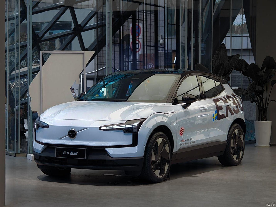 White Volvo EX30 electric SUV on display, featuring sleek design and Red Dot 2024 award badge